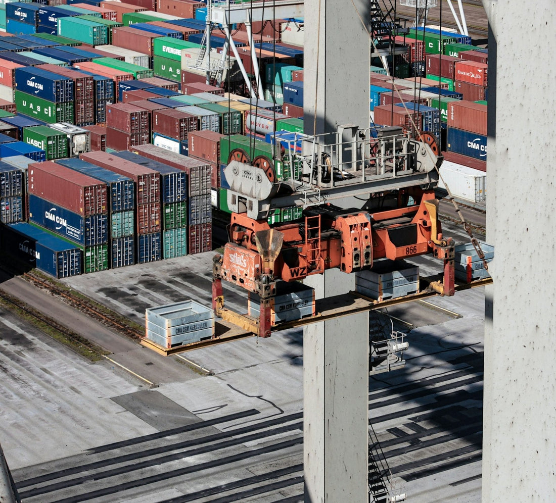 Aerial view of cargo containers and a crane at a shipping port