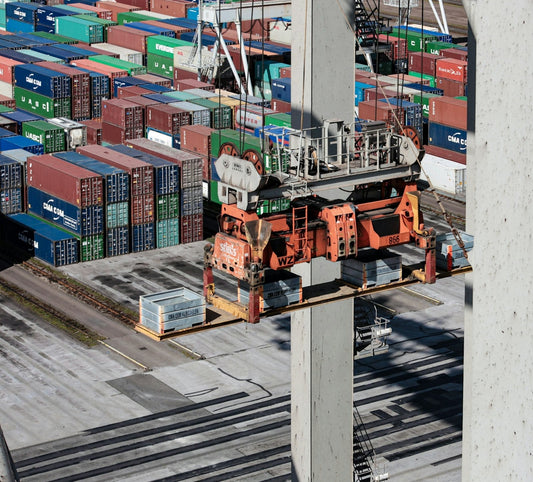 Aerial view of cargo containers and a crane at a shipping port